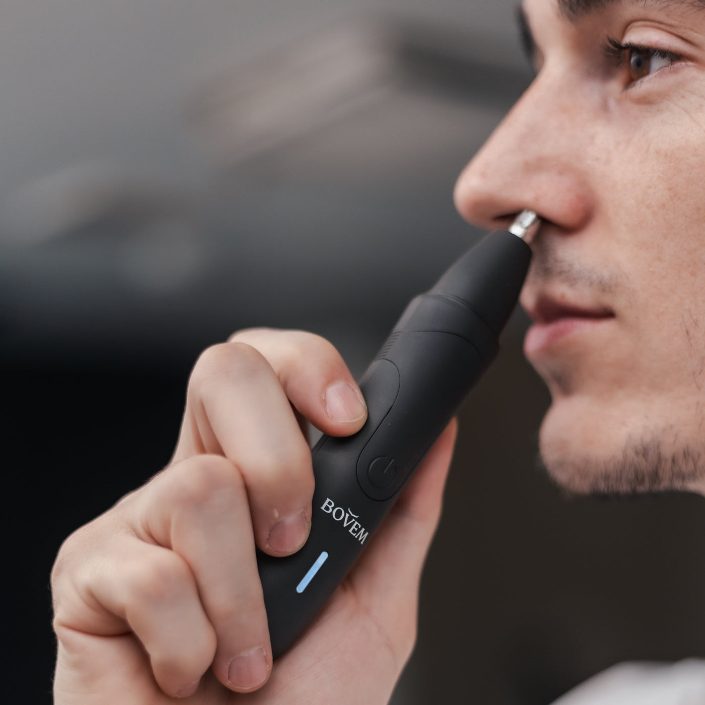 man trimming nose hair with nose trimmer