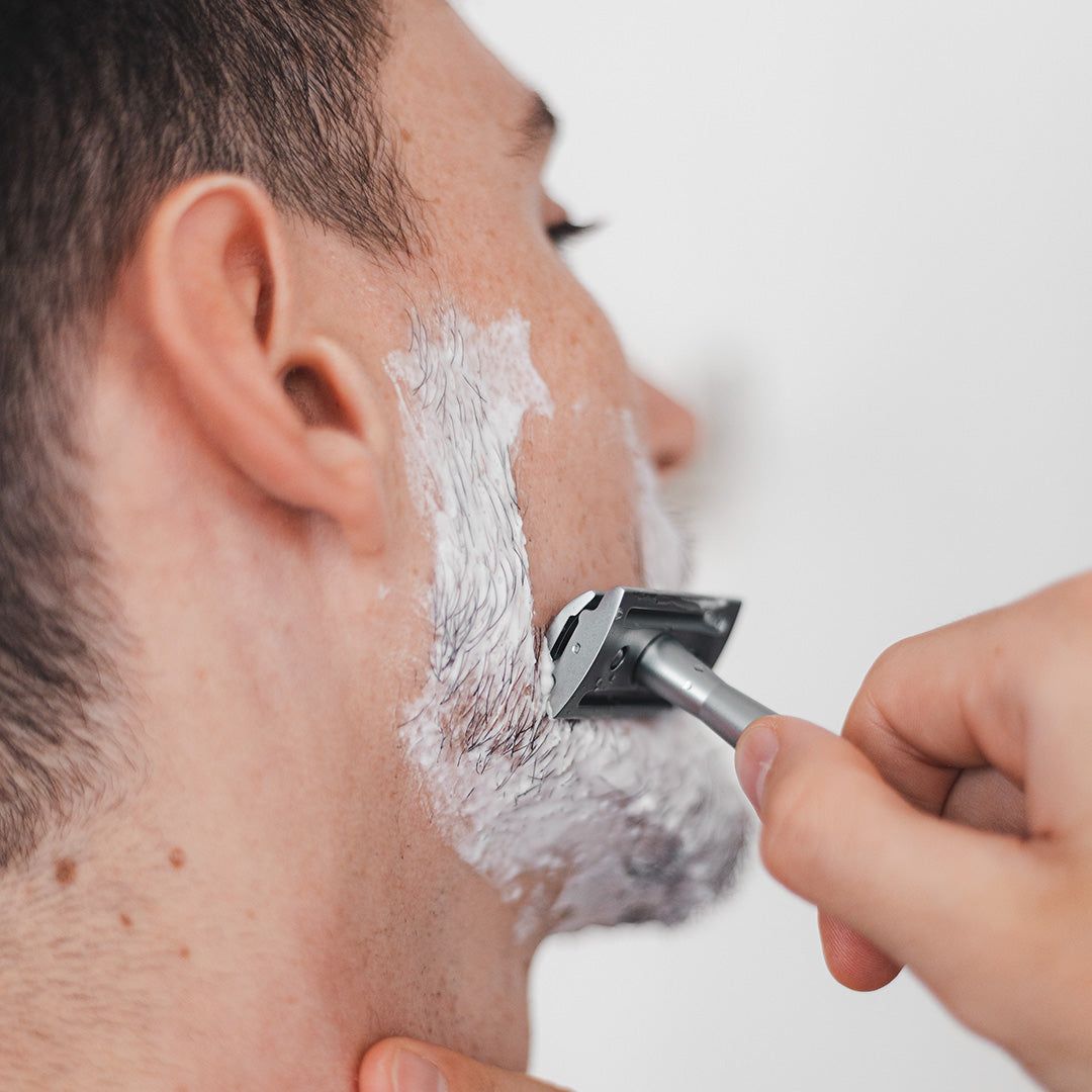 man shaving face with facial lather